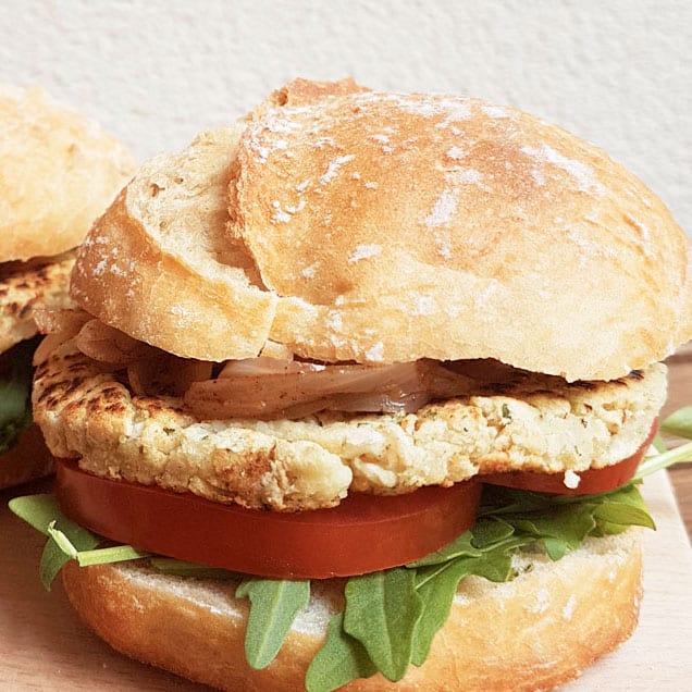 Hamburguesa vegana de habas frescas con rúcula y cebolla caramelizada